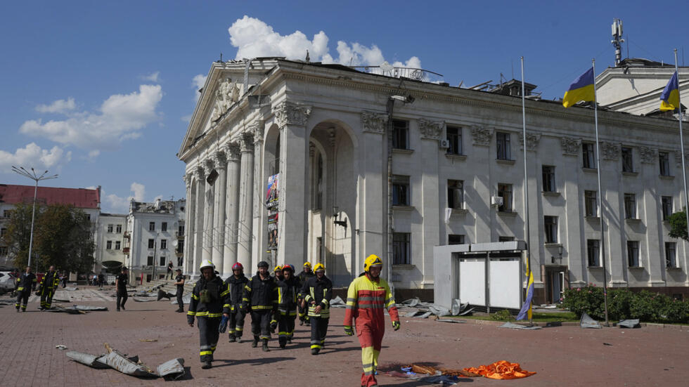 Des pompiers à côté du théâtre Tchernihiv endommagé par une frappe russe, le samedi 19 août 2023.