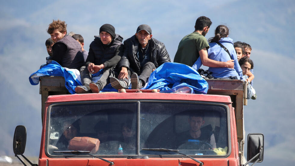 Les réfugiés de la région du Haut-Karabakh montent dans un camion à leur arrivée au village frontalier de Kornidzor, en Arménie, le 27 septembre 2023.