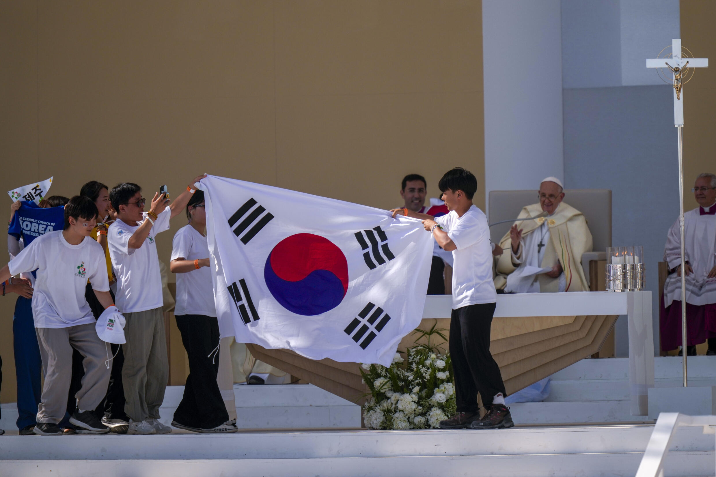 De jeunes pèlerins de Corée du Sud célèbrent avec leur drapeau national et le pape François après l'annonce de Séoul pour les JMJ 2027, ce dimanche 6 août 2023 près de Lisbonne.